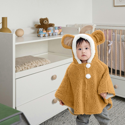 enfant dans chambre avec poncho bébé pompon