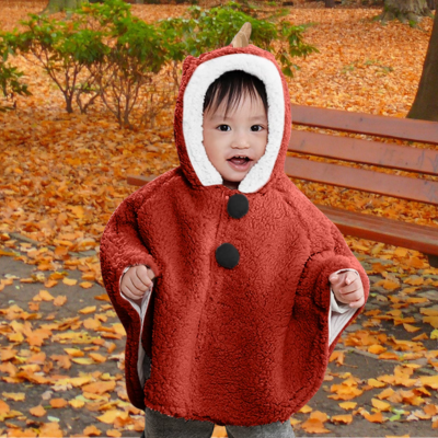 enfant balade au parc avec poncho bébé pompon rouge