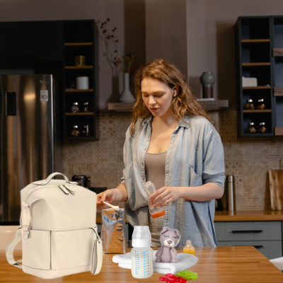 Maman dans la cuisine prépare biberon de bébé son sac a langer bebe sur la table.