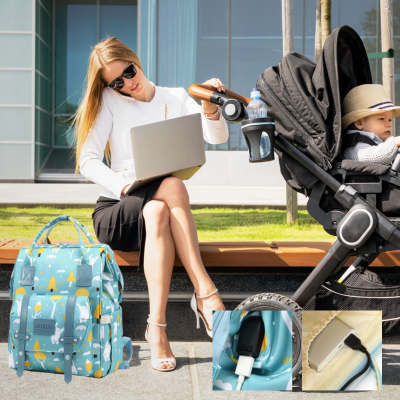 Maman assise travaille ordinateur avec sac a langer bebe skyblue.